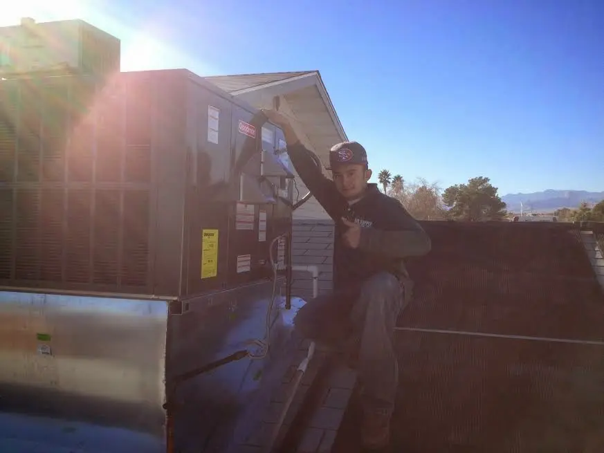 HVAC technician performing AC Tune-Up on a rooftop unit in Maplewood